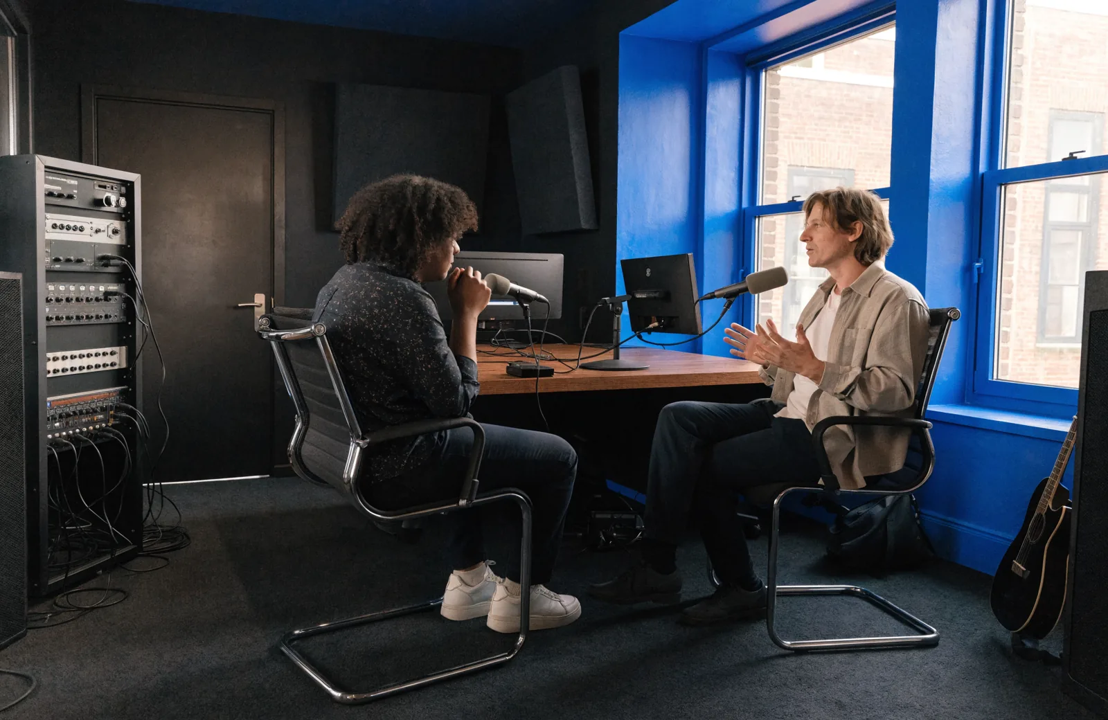 Illustration IA : échange entre deux personnes autour de microphones.